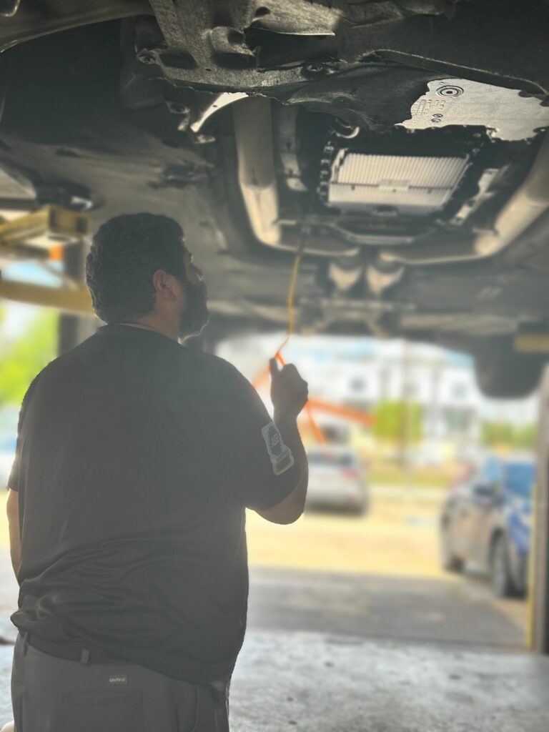 technician performing transmission fluid service in Houston