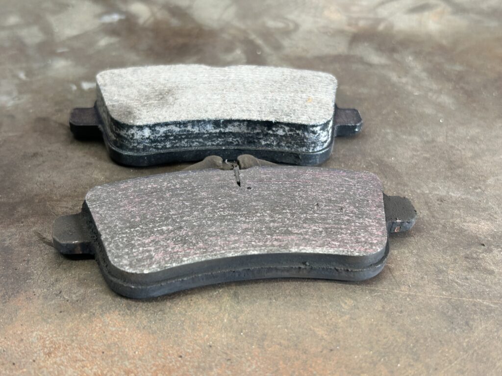 Worn vs new brake pads showing thickness difference during brake repair in Houston TX