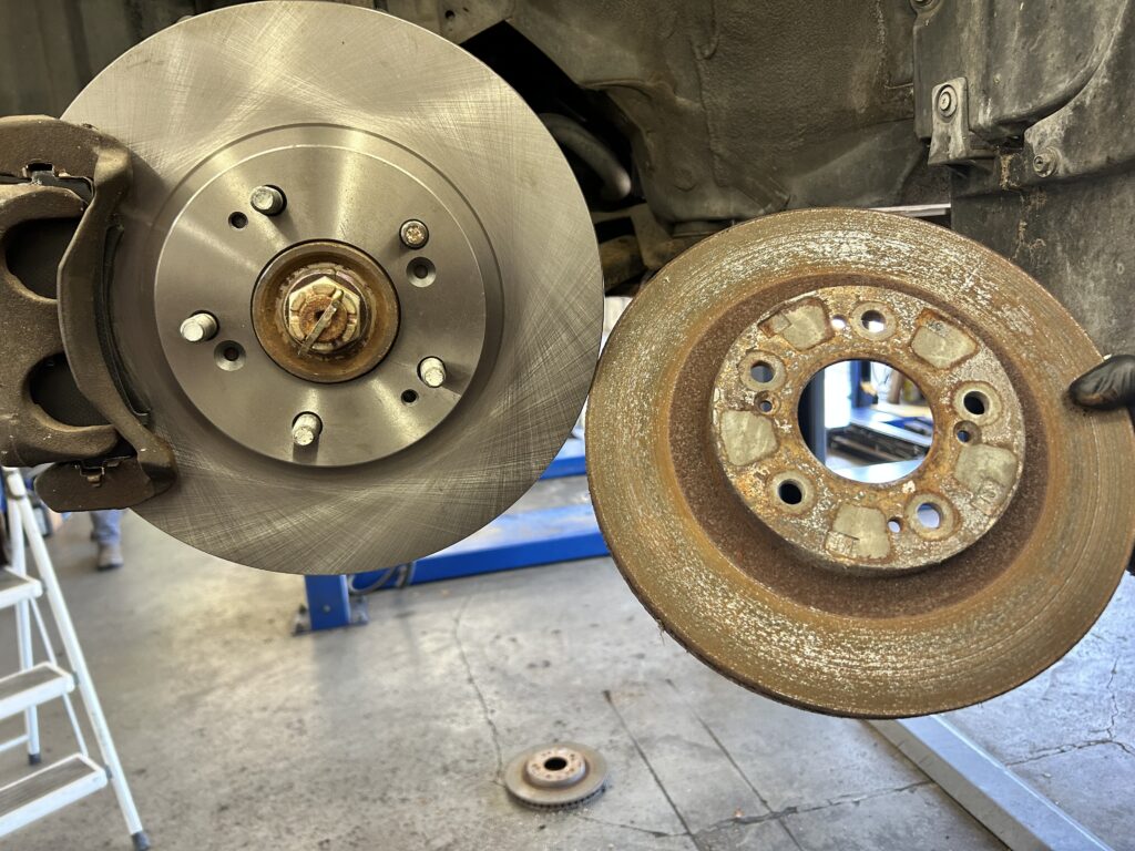 New vs rusted brake rotor comparison during brake repair in Houston TX
