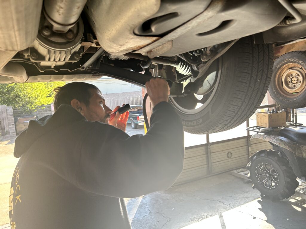 vehicle inspection during oil change in Houston checking undercarriage components