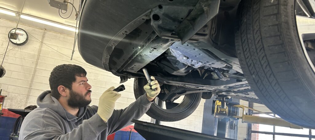 Technician performing preventative car maintenance in Houston auto repair shop