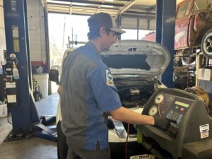 auto ac repair houston technician using ac machine