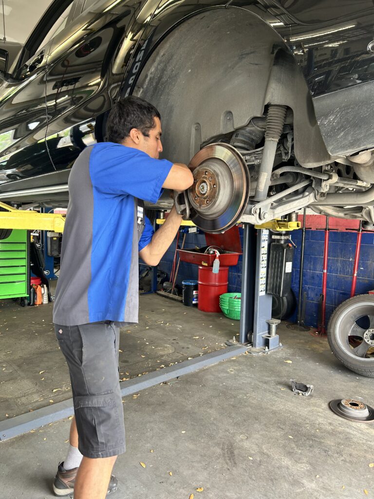Brake repair technician working on vehicle Houston TX