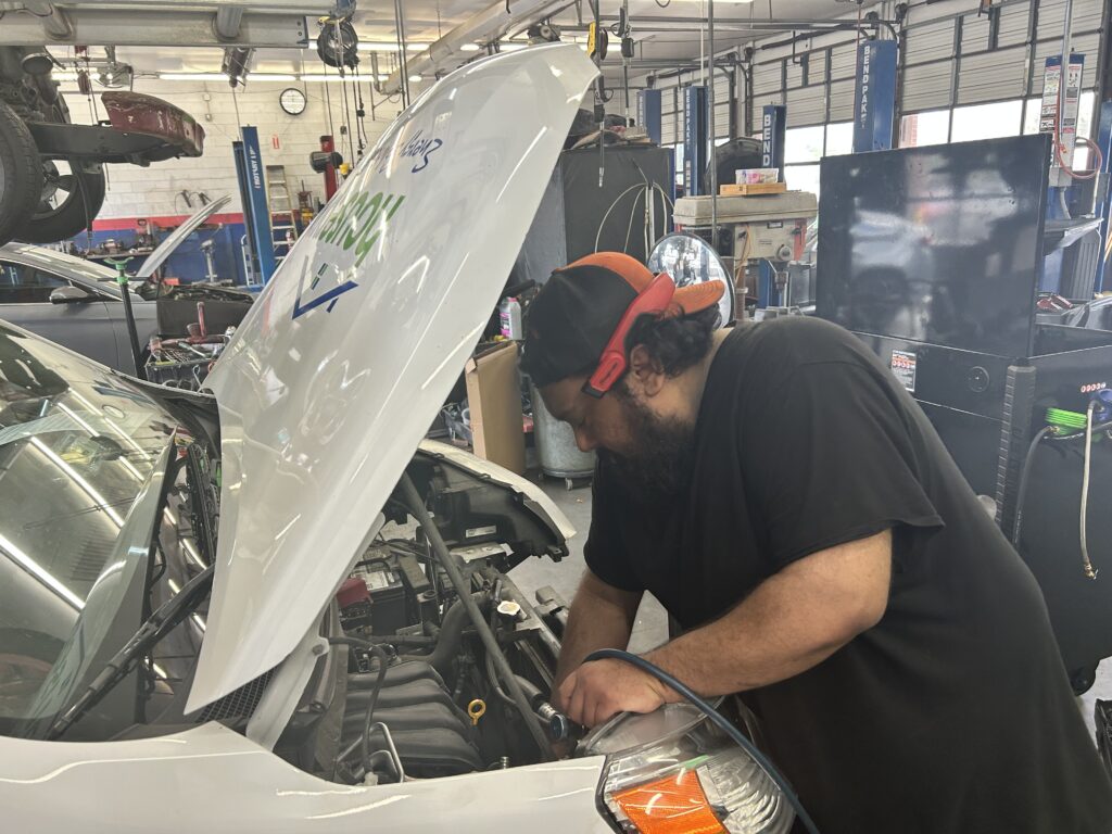 Technician diagnosing engine issue at auto repair shop in Houston Galleria area