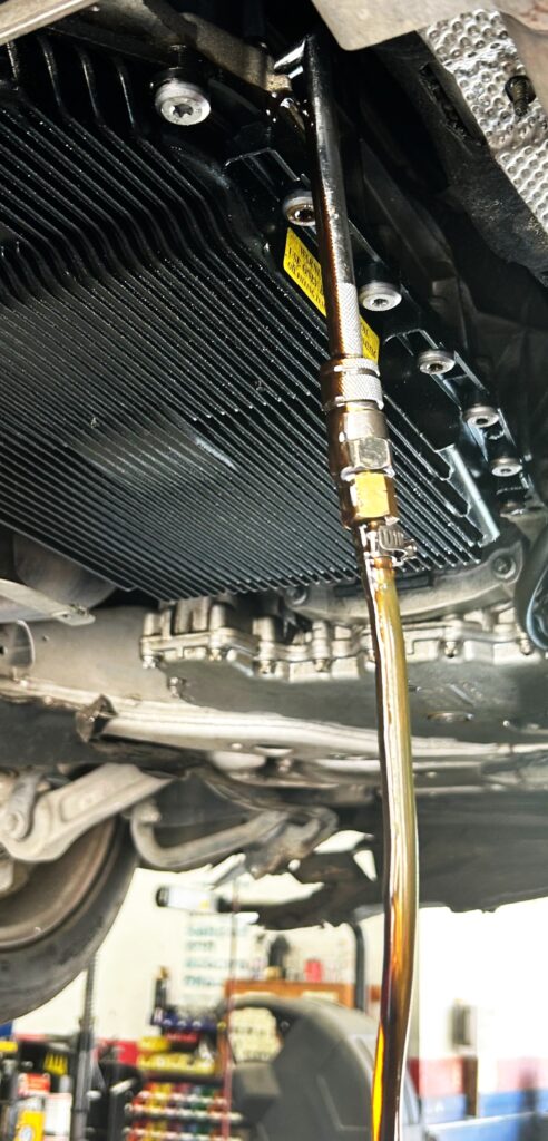 Transmission fluid service on BMW showing fluid condition in Houston auto repair shop