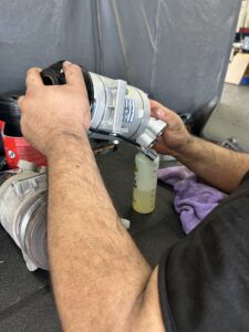 Technician preparing replacement AC compressor during repair in Houston, TX