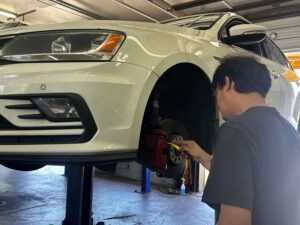 technician inspecting volkswagen brakes at Chimney Rock Car Care in Houston