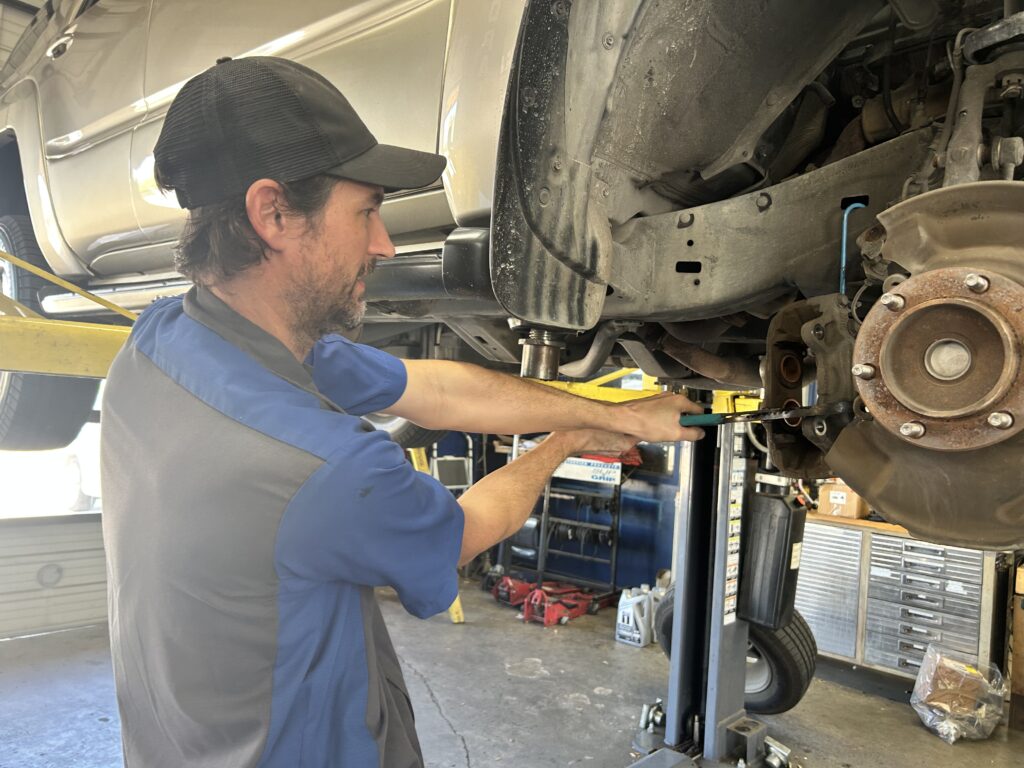 Technician checking front brake pistons on Toyota 4Runner