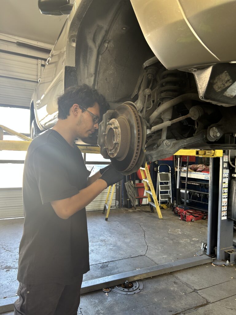 Technician inspecting front brake system on Toyota 4Runner in Houston