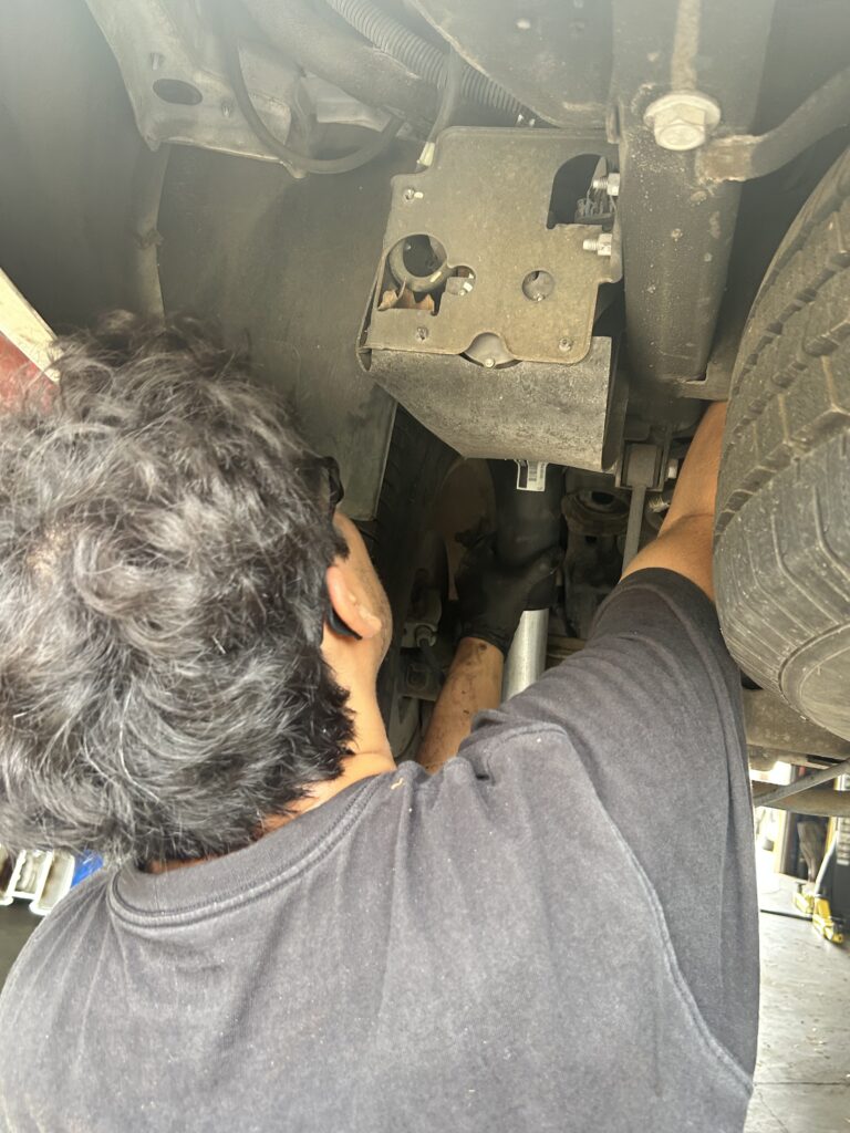 Technician replacing rear air suspension strut on Chevrolet Tahoe
