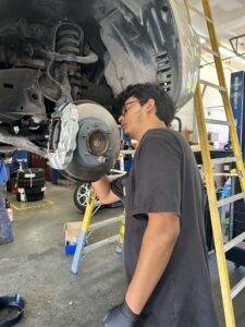 Technician installing new brake caliper and rotor on Toyota 4Runner in Houston