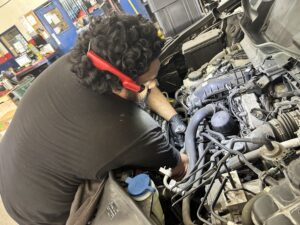 Technician diagnosing a coolant leak at Chimney Rock Car Care in Houston.