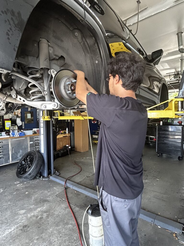 Technician performing a brake fluid flush at Chimney Rock Car Care in Houston, TX