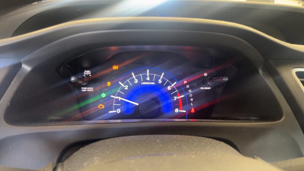 Check engine light and other warning lights illuminated on a vehicle dashboard