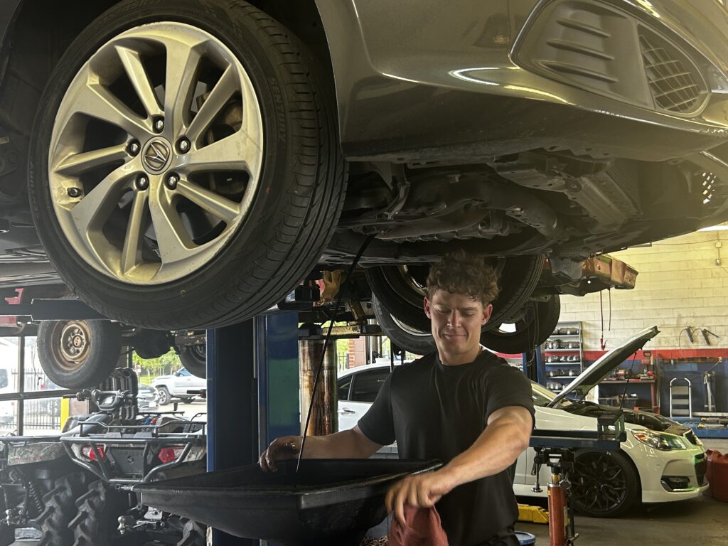 Technician performing an oil change at Chimney Rock Car Care in Houston, TX
